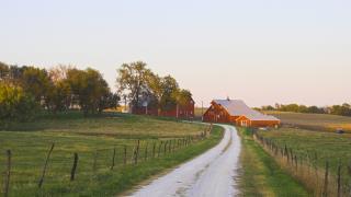 green field with farm in the background