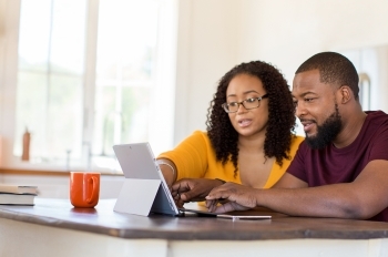 middle age couple at table with laptop