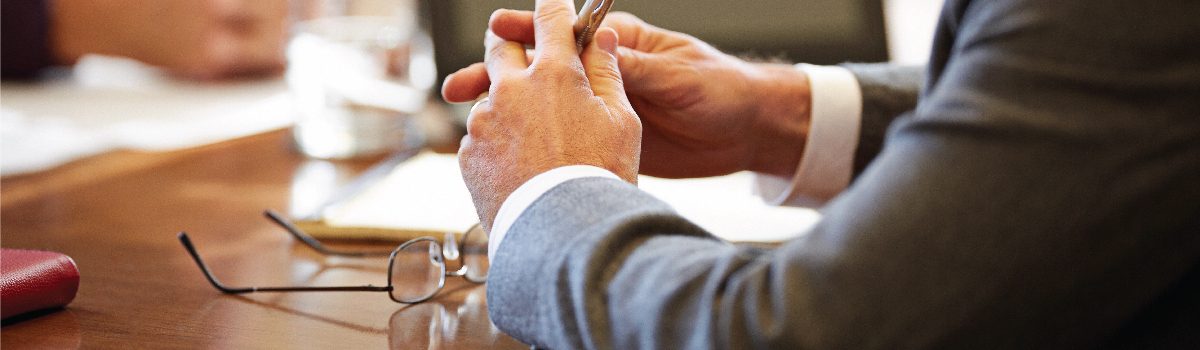 business people's arms and hands at a conference table