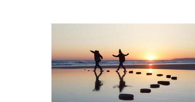 two people on a beach at sunset