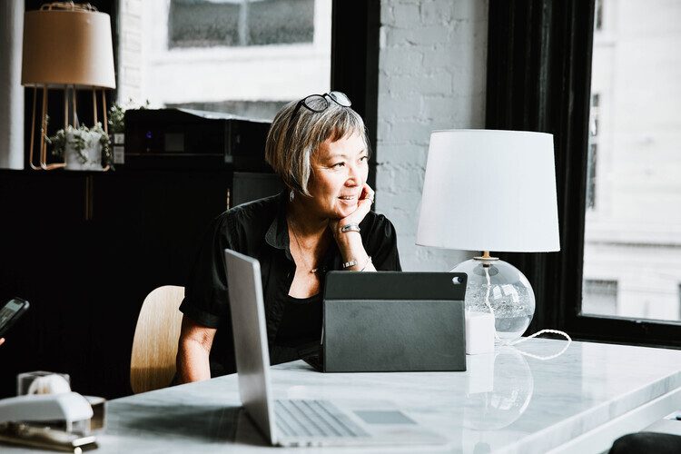 woman sitting at desk using tablet