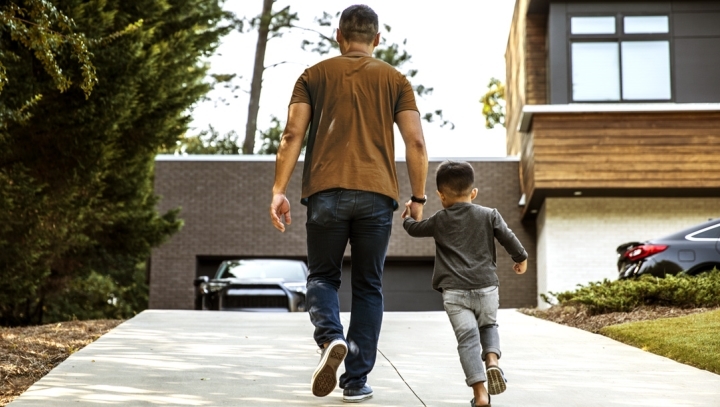 Man and his son walking and holding hands