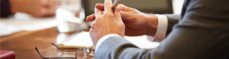 business people's arms and hands at a conference table