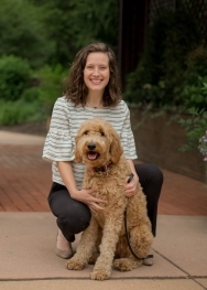 white woman with brown hair in striped blouse with dog