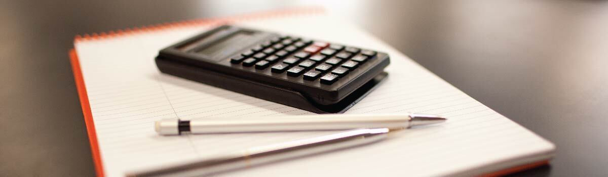 calculator, pen, and papers on desk