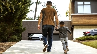 Man and his son walking and holding hands