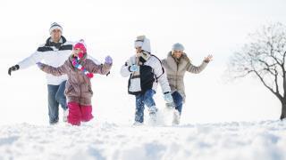 family playing in the snow