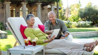 couple reviewing tablet together by pool