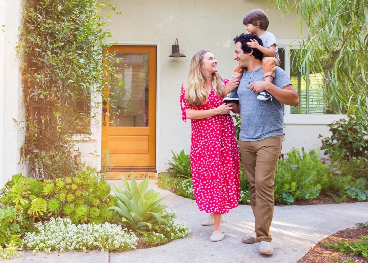 young family walking out of house