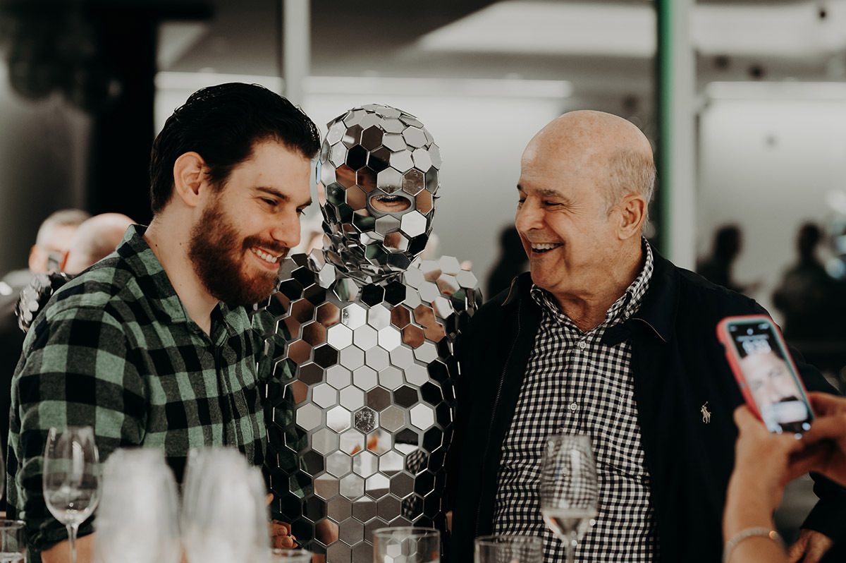 2 client smiling and laughing with one person dressed in silver mirror outfit