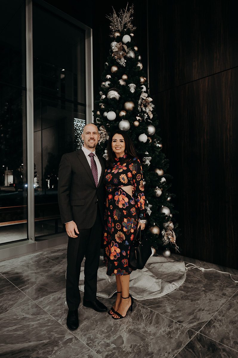 2 clients posing infront of a christmas tree