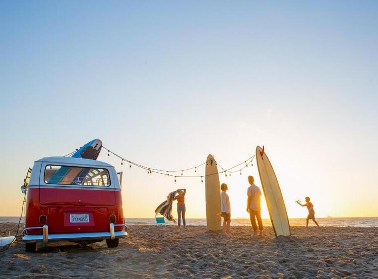 van and surfboards on beach