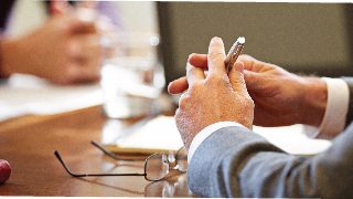 business people's arms and hands at a conference table